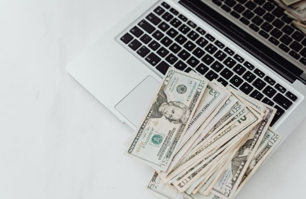An image of dollar bills on a laptop.