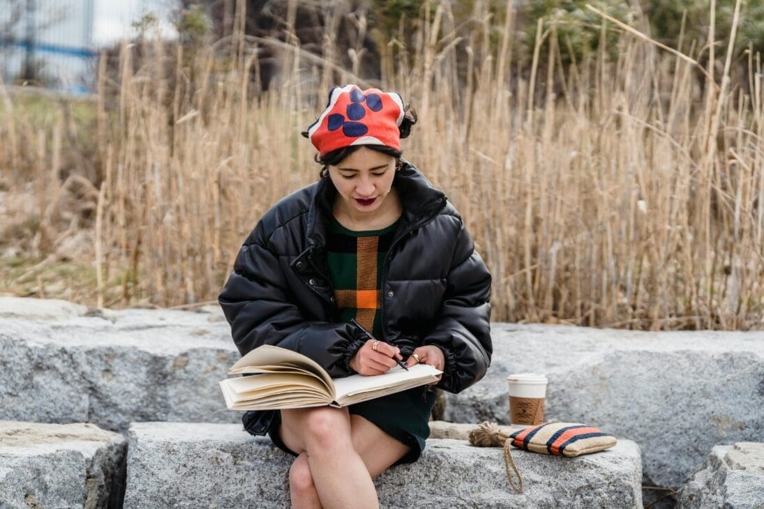 Notebook and pen held outside, starting a social media detox diaries entry
