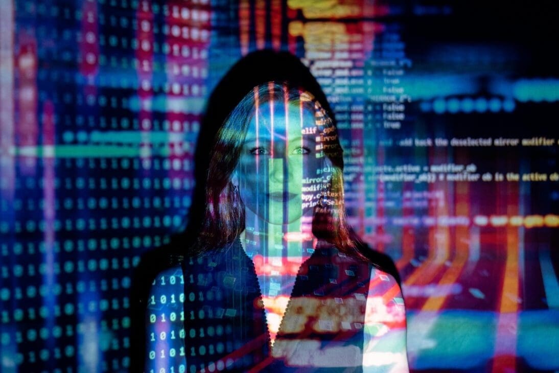 A woman surrounded by vibrant digital colors symbolizing the fusion of artificial intelligence and human connection.