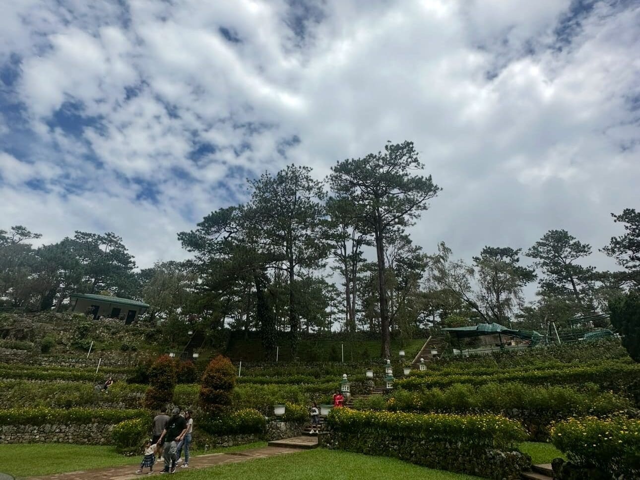 Bell Amphitheater at Camp John Hay surrounded by tall pine trees and walking paths in Baguio