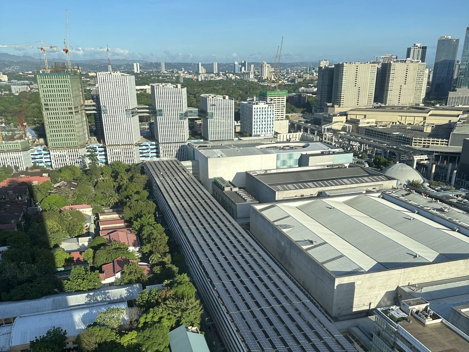 View of Manila city skyline from hotel window, capturing bustling buildings and urban energy.